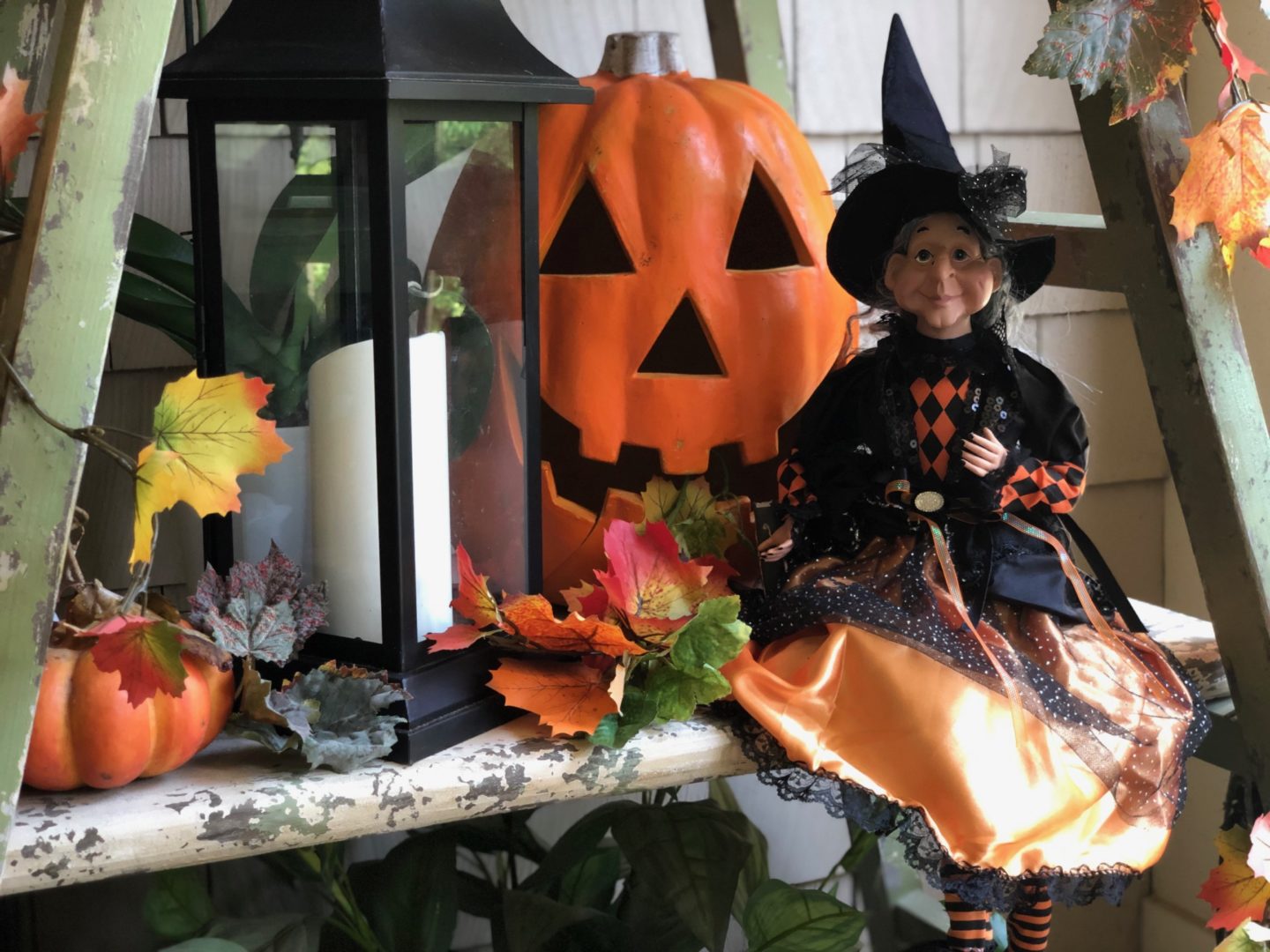 A witch and Halloween decor on the porch