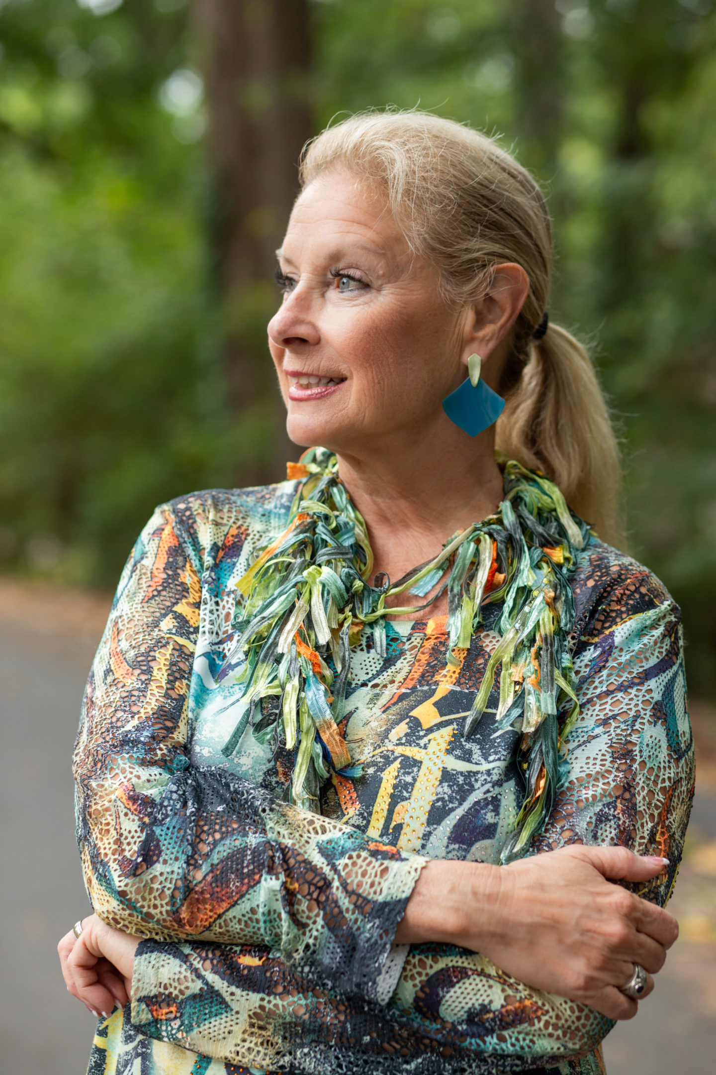 Robin is wearing Kendra Scott earrings and a silk fabric strips necklace