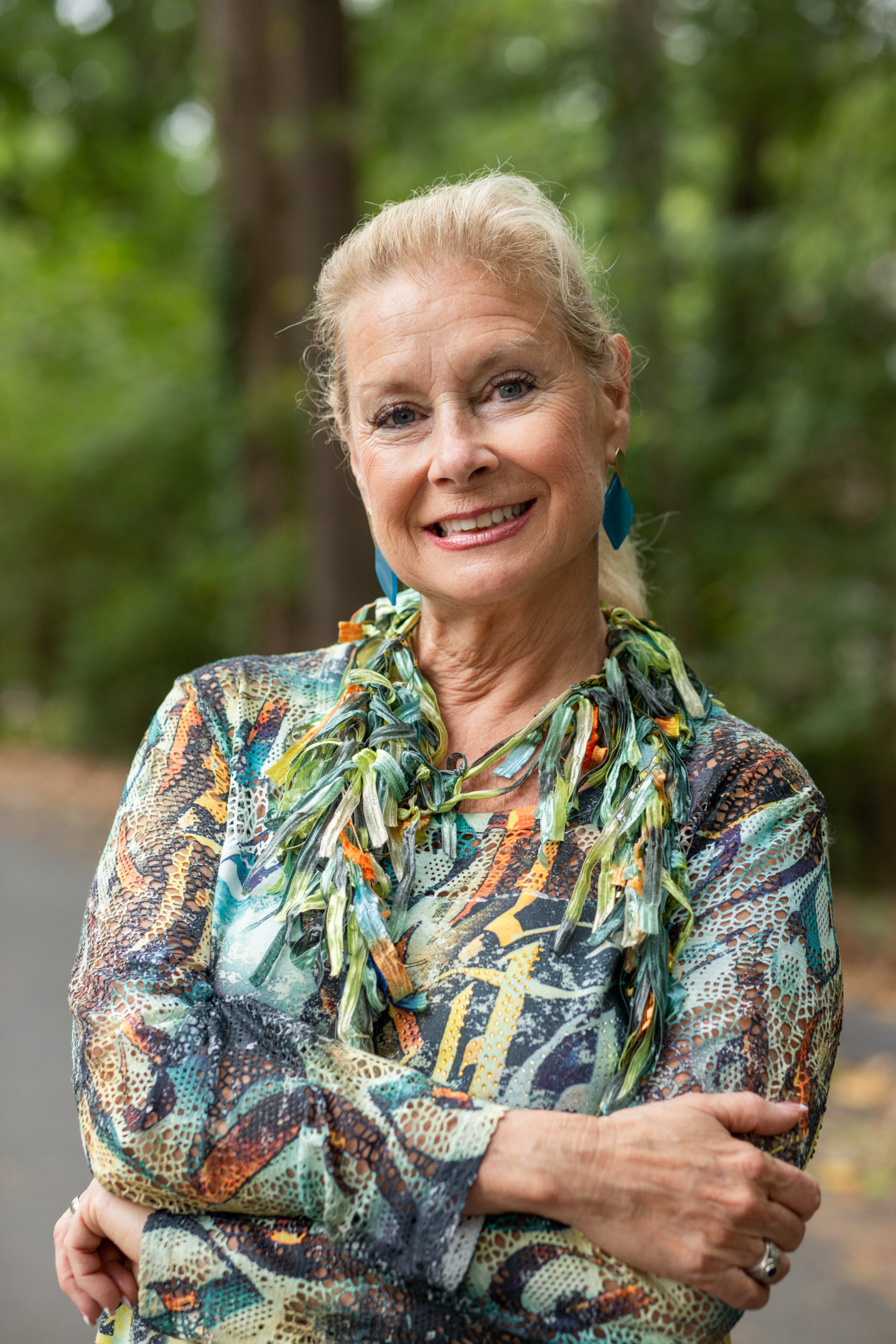 Robin is wearing Kendra Scott earrings and a silk fabric strips necklace