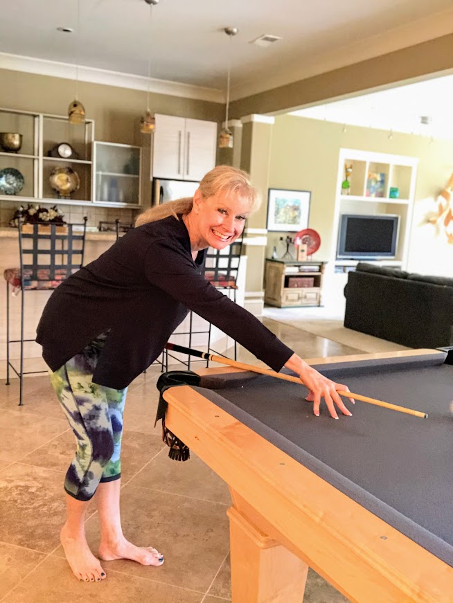Robin is wearing athleisure clothing from Peach while playing pool