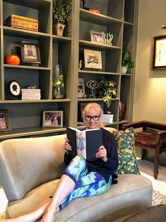 Robin is wearing athleisure clothing from Peach while reading a book while staying at home