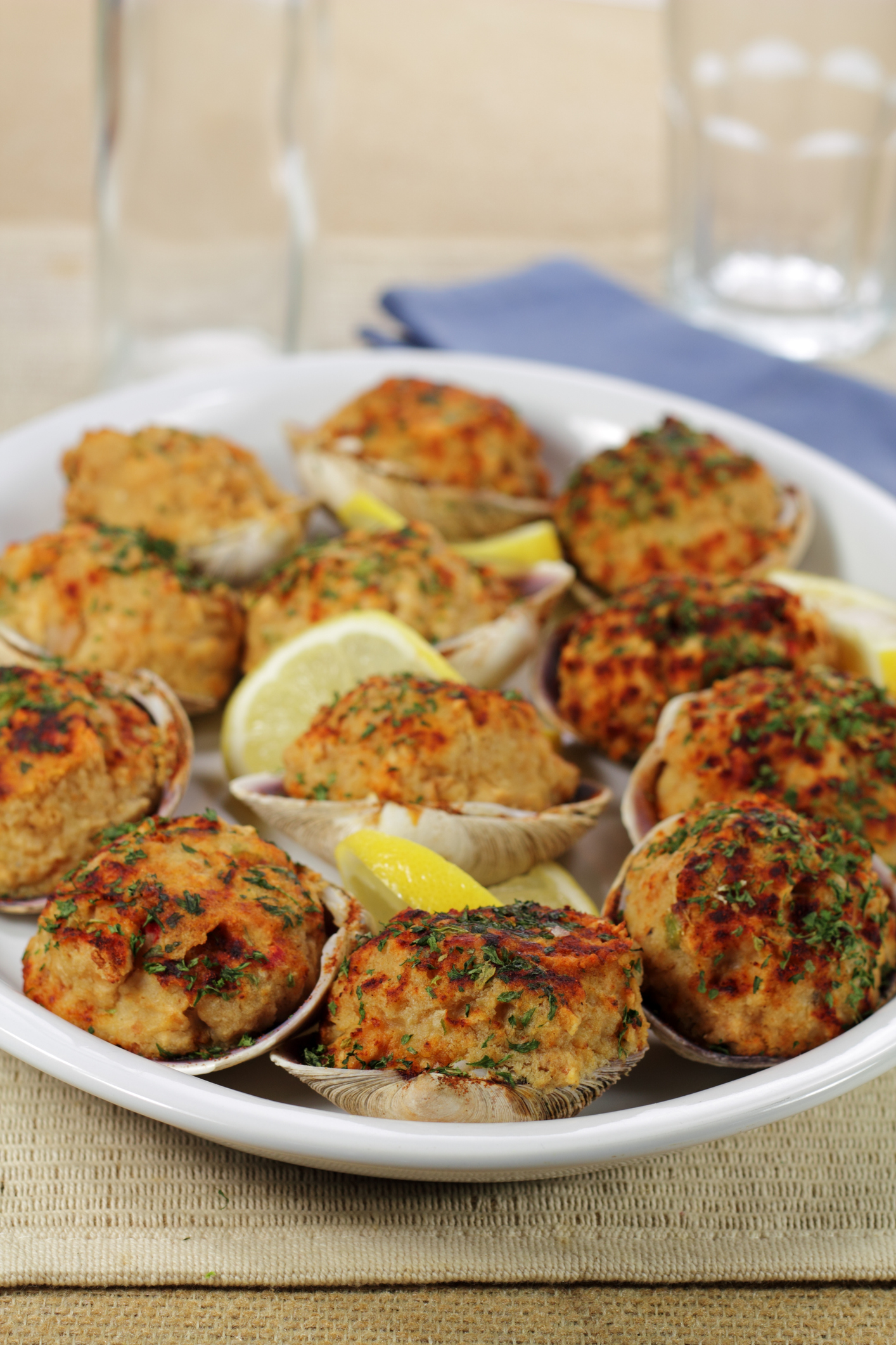 A platter of stuffed clams with lemon garnish