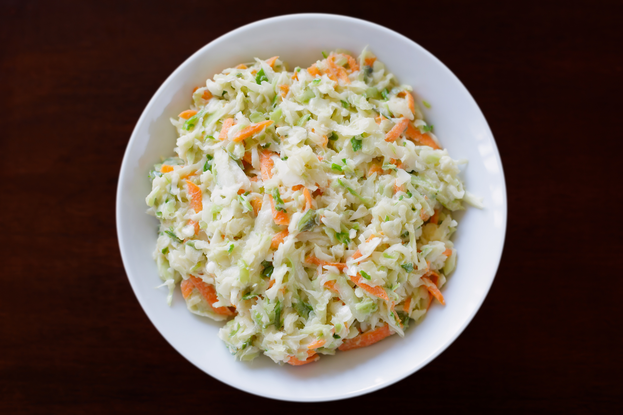 Finely chopped coleslaw served in a white bowl. Single bowl used to enhance slaw.
