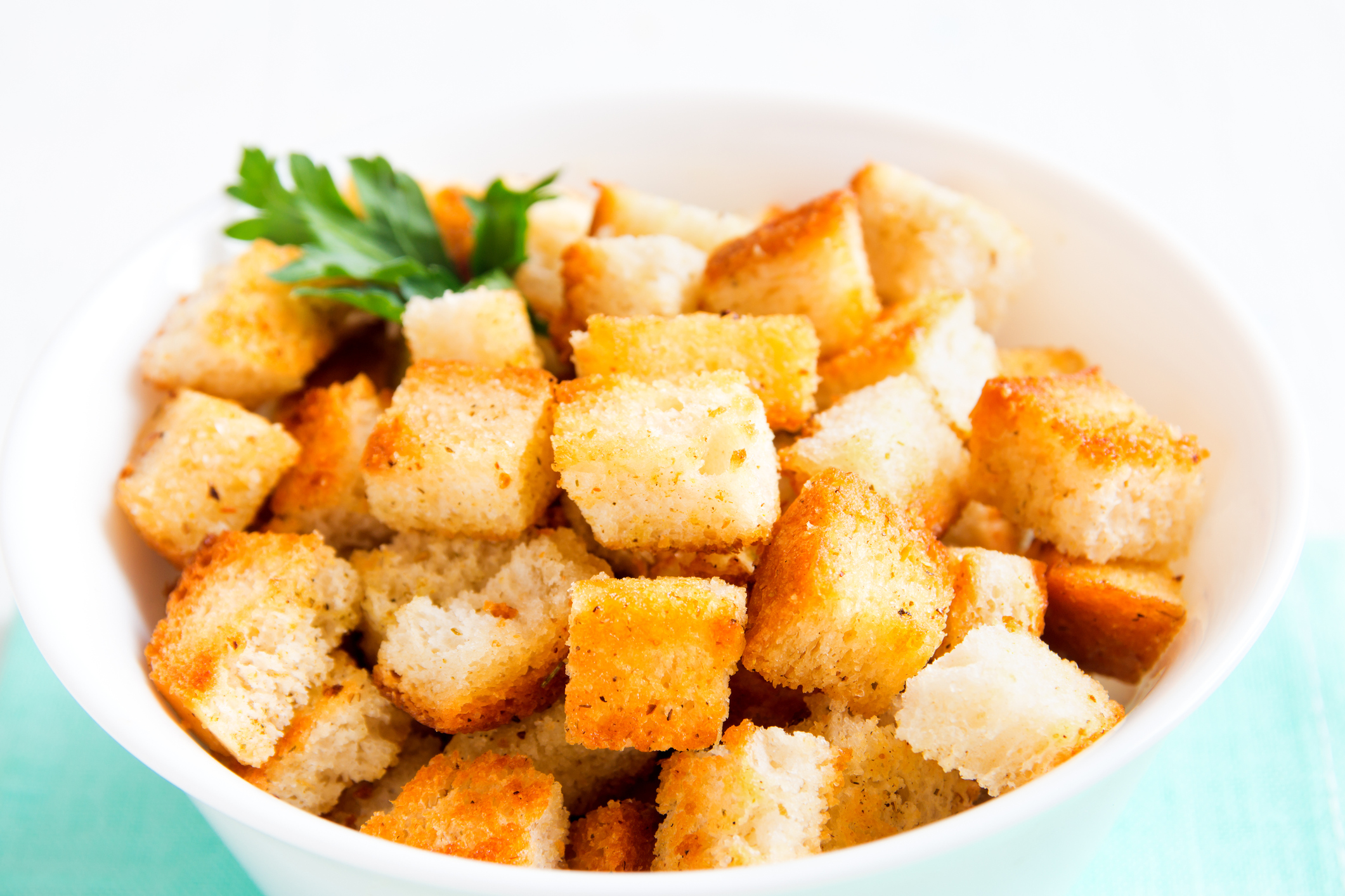 Homemade french croutons in white bowl close up