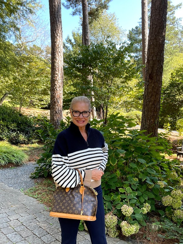 wearing striped sweater and navy pants
