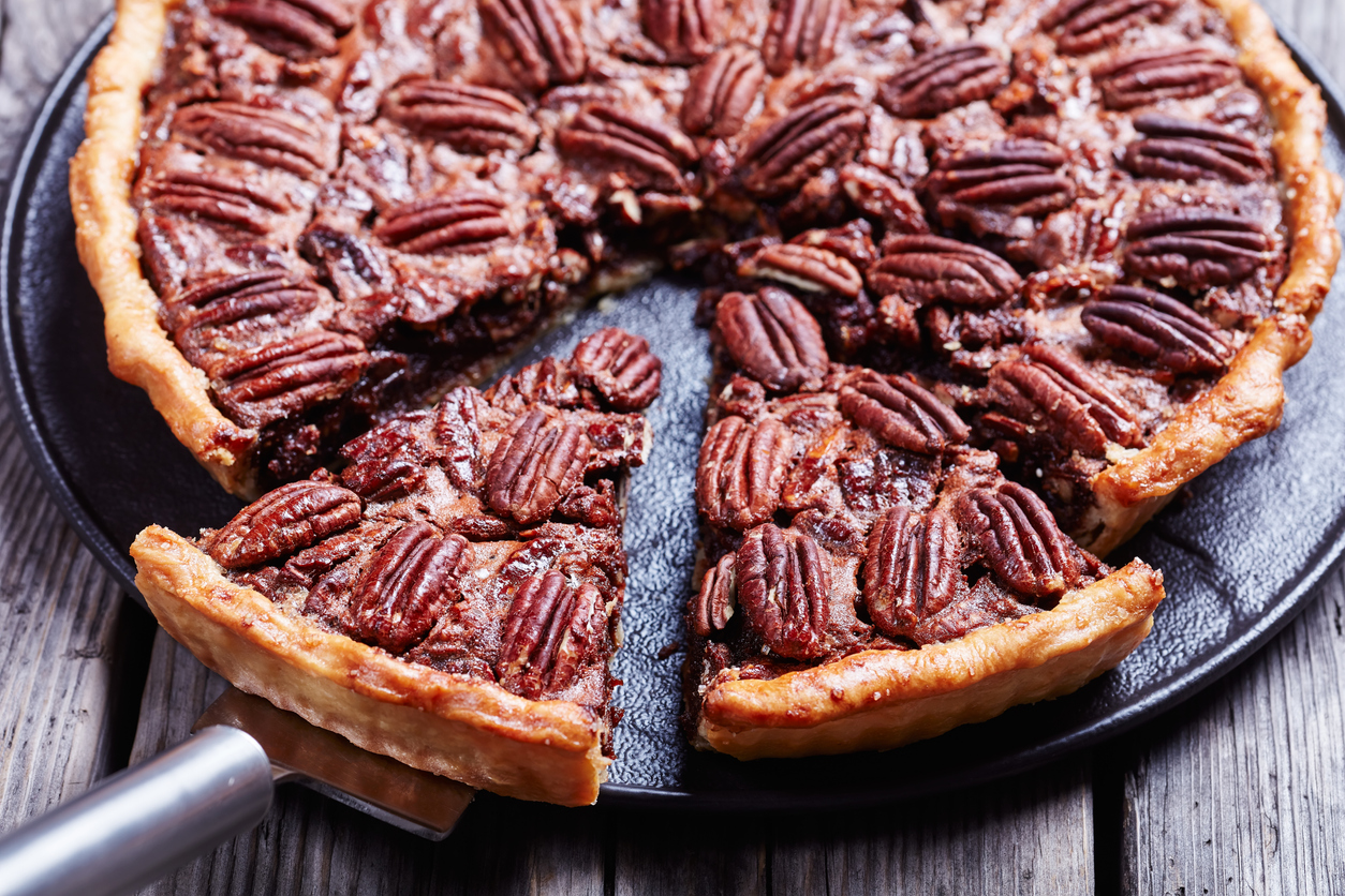 pecan pie on a black stone plate on an old wooden rustic table, 
