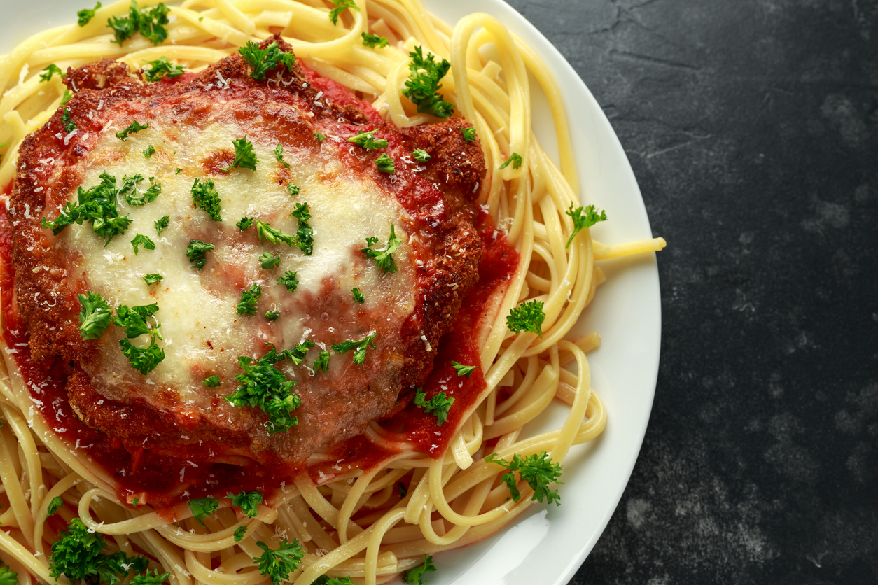 Chicken or Veal Parmesan with Cheese and Marinara Sauce served over spaghetti, pasta.