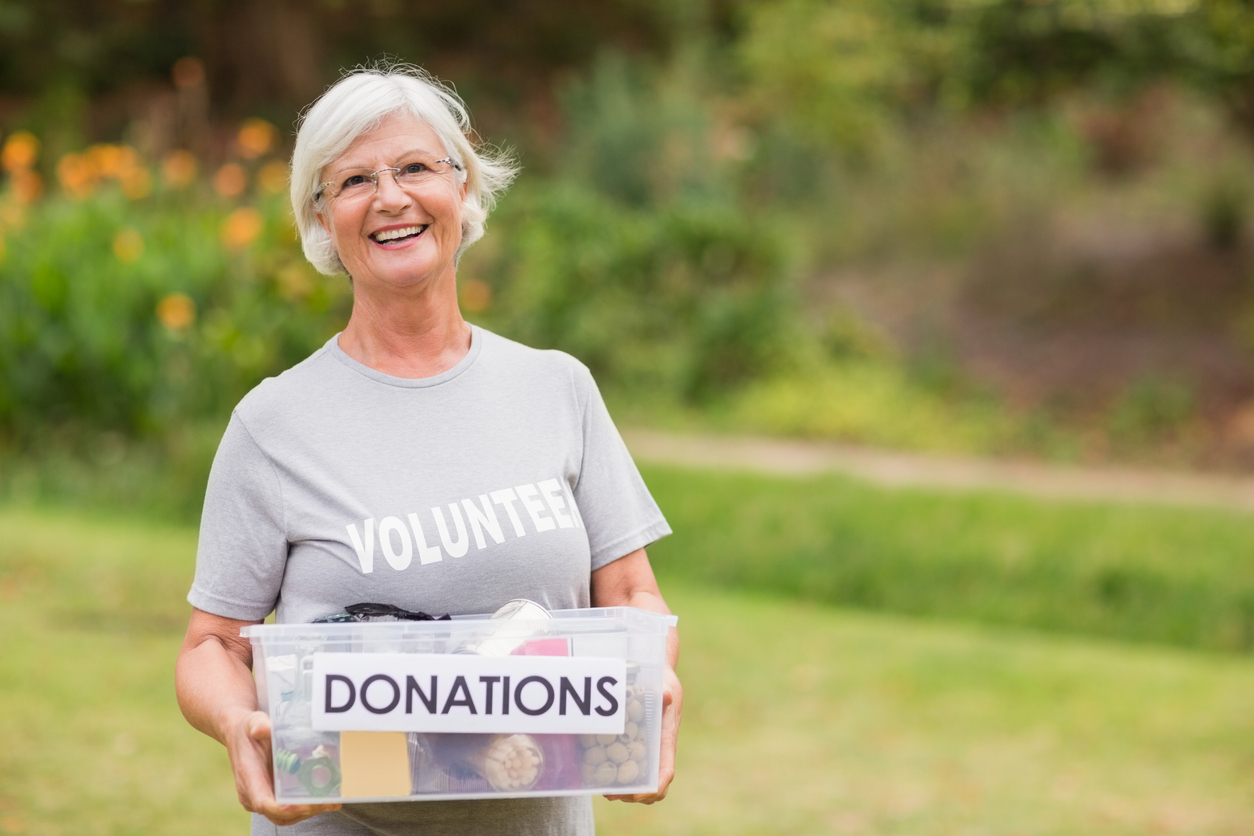 Happy grandmother holding donation box on a sunny day