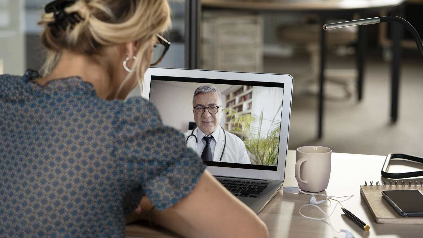 Young woman talking with doctor on digital tablet