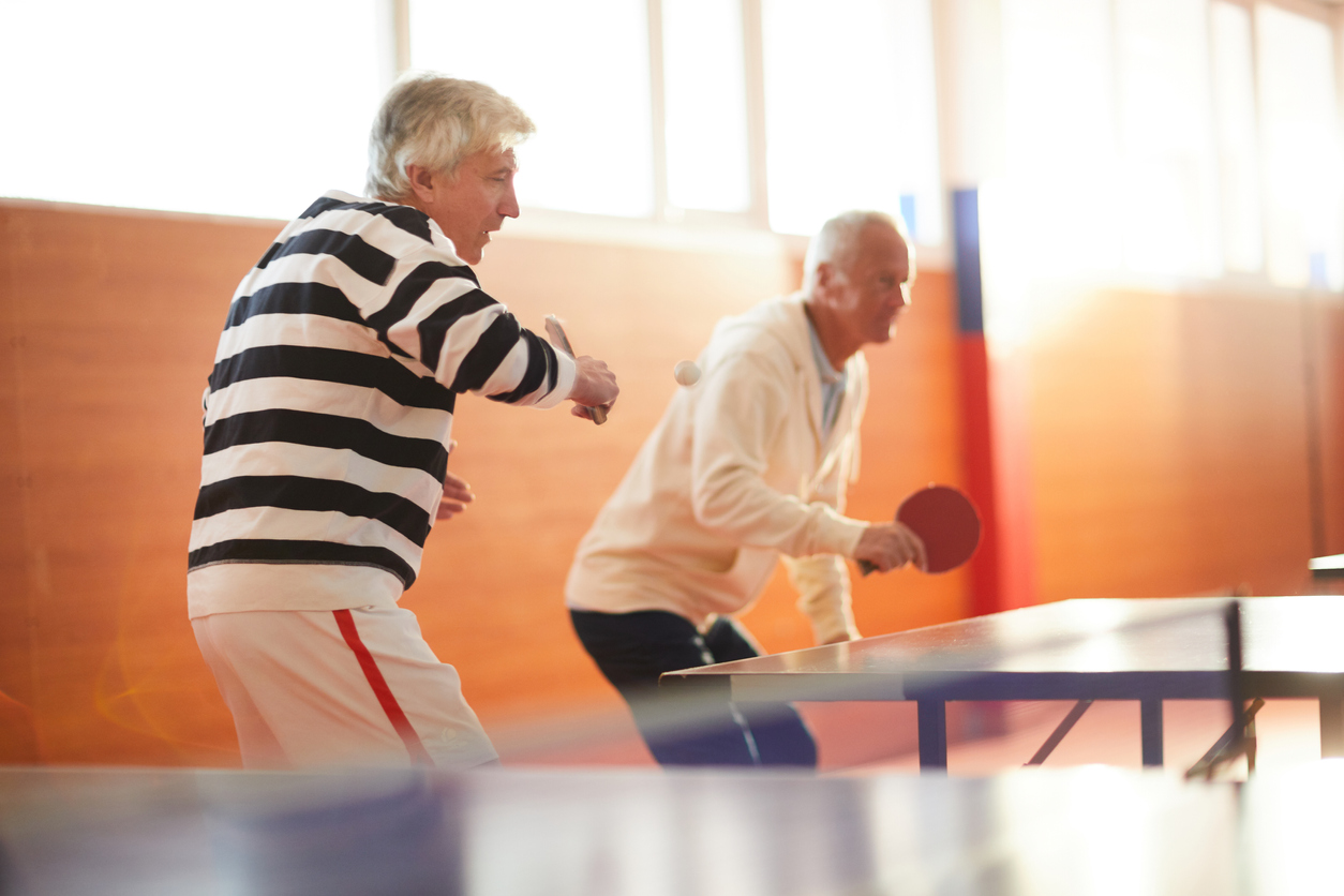 Two active senior men playing table tennis