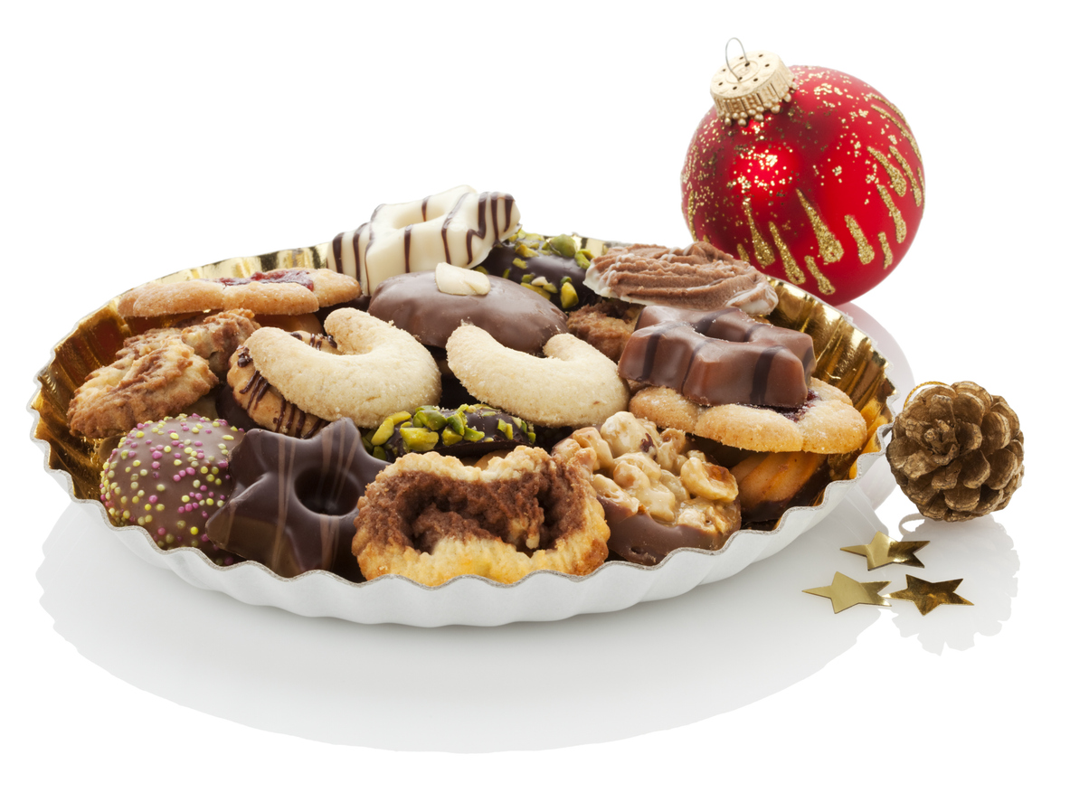 Christmas cookies on a plate with ornaments on white background