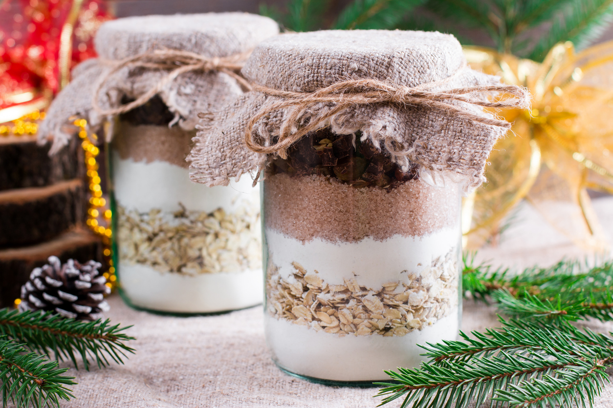 Chocolate chips cookie mix in glass jar over xmas background.